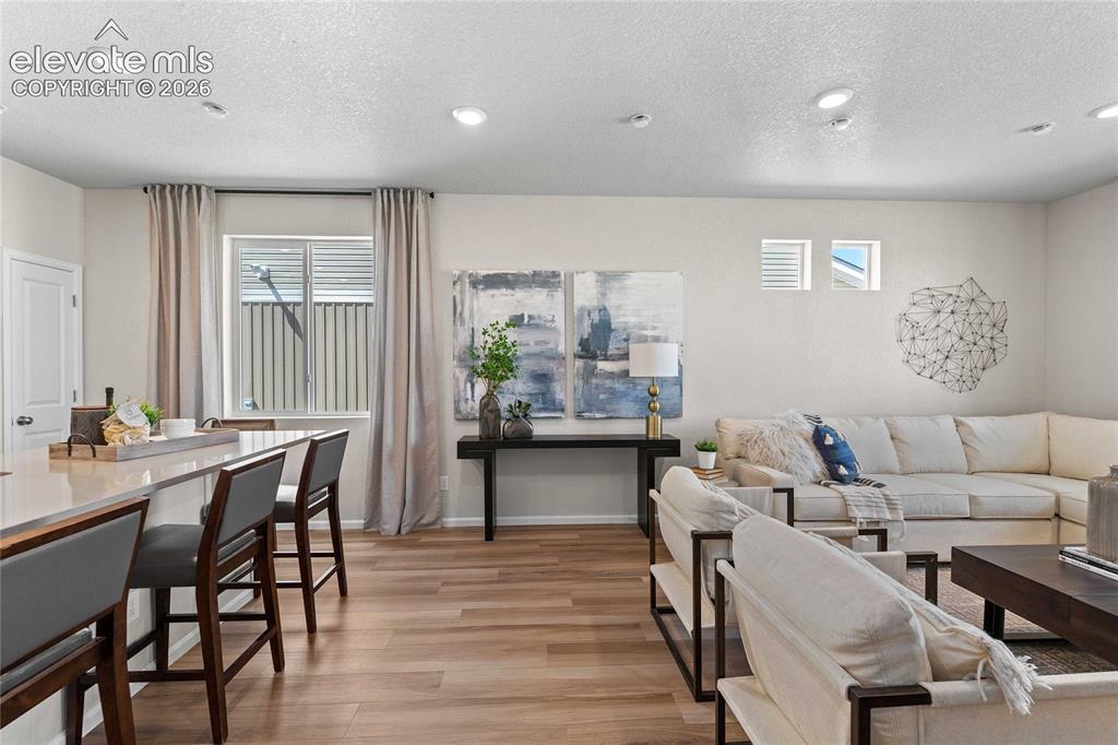 Image 7 of 25: Open-concept living area featuring recessed lighting, wood-finish flooring,