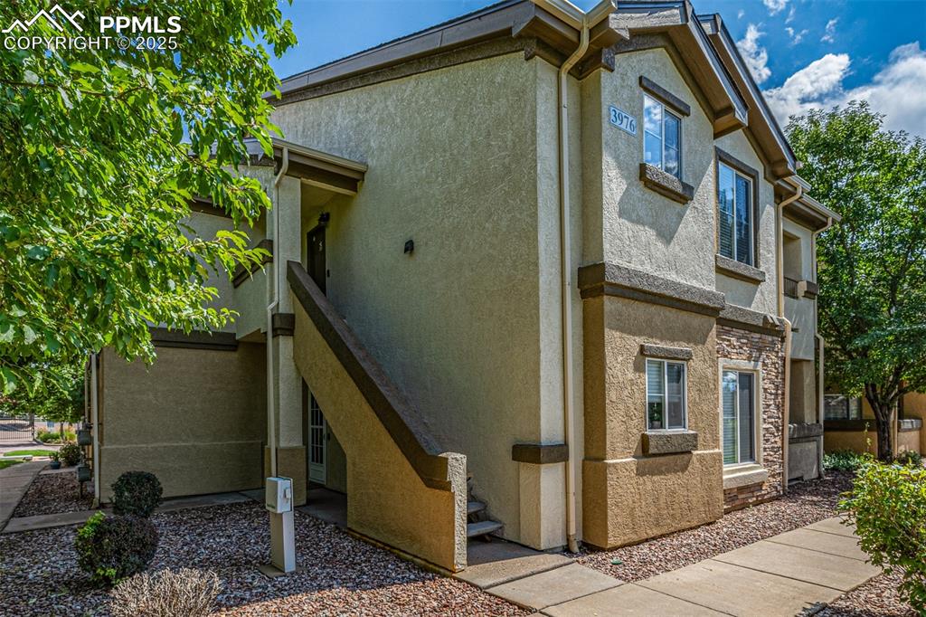 Image 3 of 24: View of side of home with stucco siding and stone siding