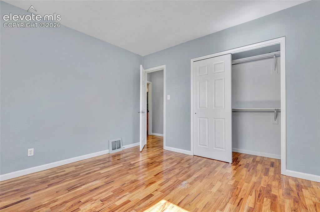 Image 17 of 39: Wood flooring, 6-panel doors, built-in closet system