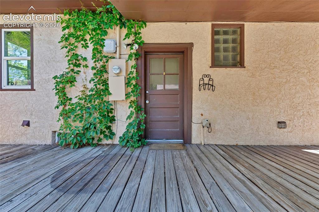 Image 37 of 39: Large, covered porch, garden beds, and fire pit
