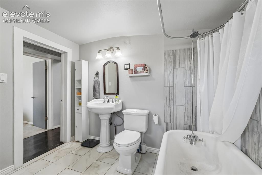 Image 30 of 43: Full bathroom plus laundry off bedroom 3