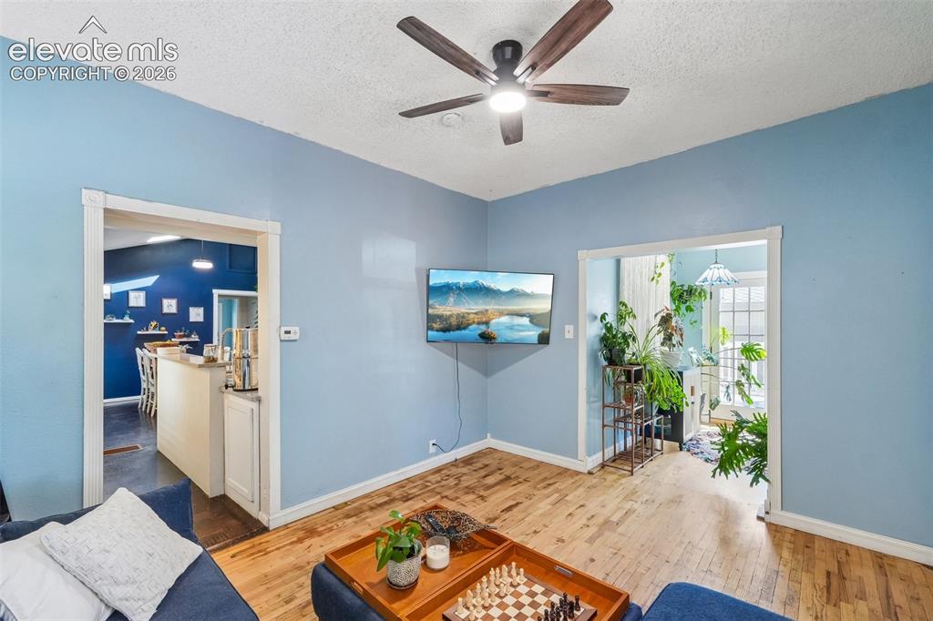 Image 8 of 43: Living room looking to sunroom and kitchen