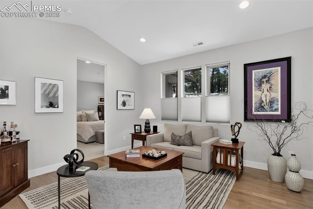 Image 17 of 32: Living room with light wood-style flooring, recessed lighting, and lofted c