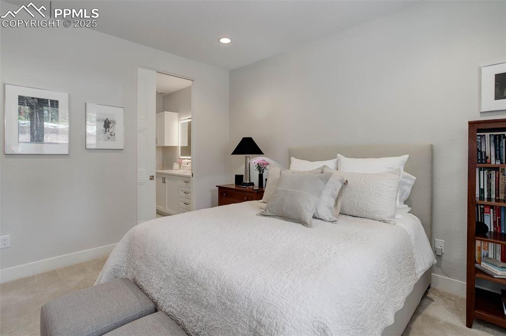 Image 19 of 32: Bedroom with light carpet, ensuite bathroom, and recessed lighting