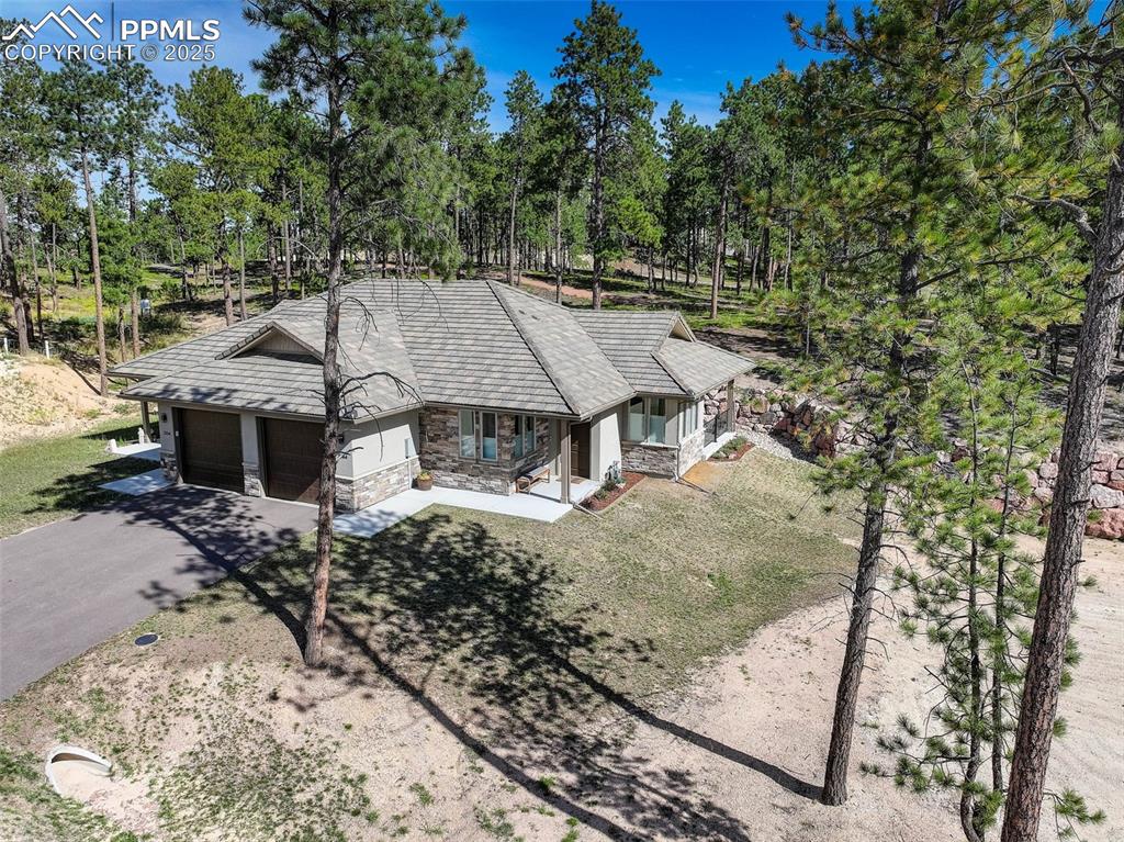 Image 7 of 32: Aerial view of property and surrounding area with a tree filled landscape