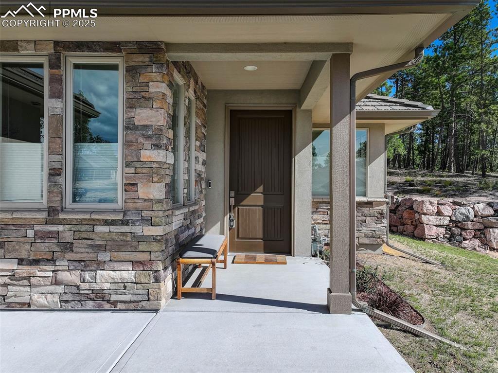 Image 8 of 32: Entrance to property featuring stone siding