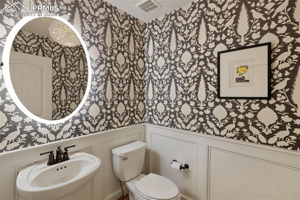 Image 14 of 49: The main-level powder room makes a sophisticated, memorable statement for v