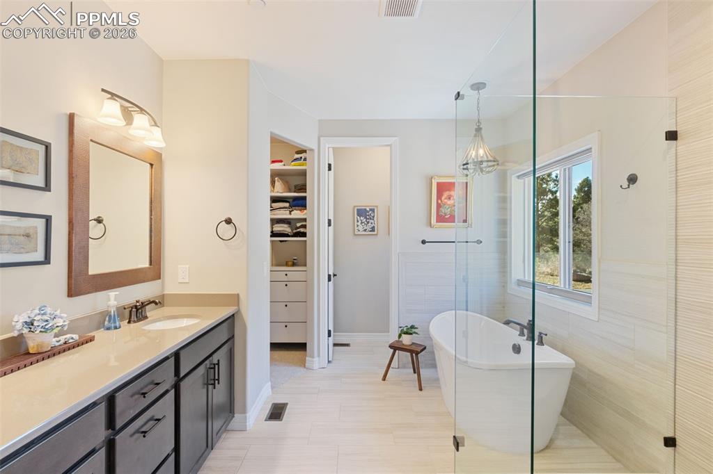 Image 19 of 49: The primary en-suite is laid out for dual daily routines, featuring dual va