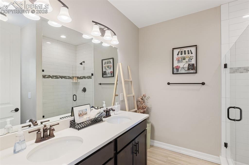 Image 24 of 49: The bathroom offers a dual vanity and a walk-in glass shower that rivals mo