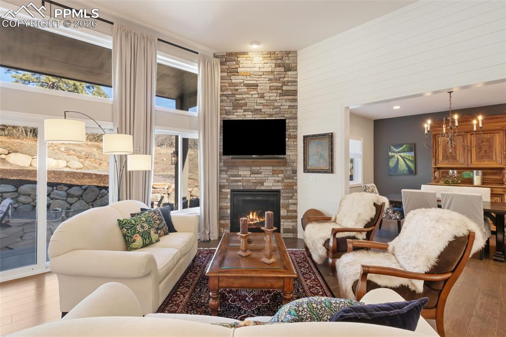 Image 4 of 49: The primary living area is anchored by a floor-to-ceiling stone fireplace, 