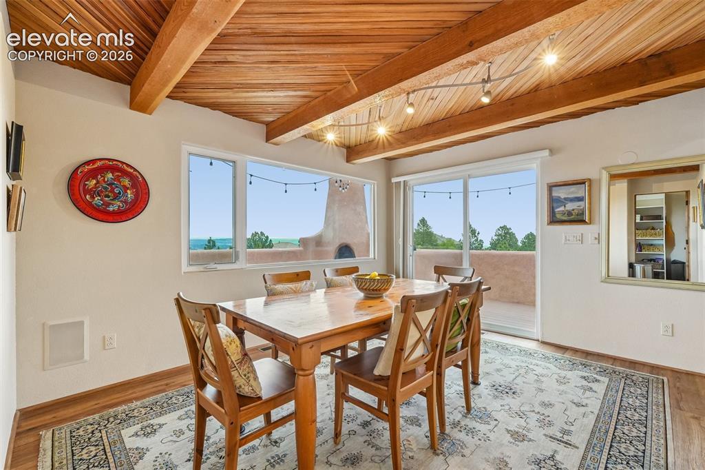 Image 13 of 50: Dining room with wood beamed ceilings, LVP flooring and a walk out to a spa