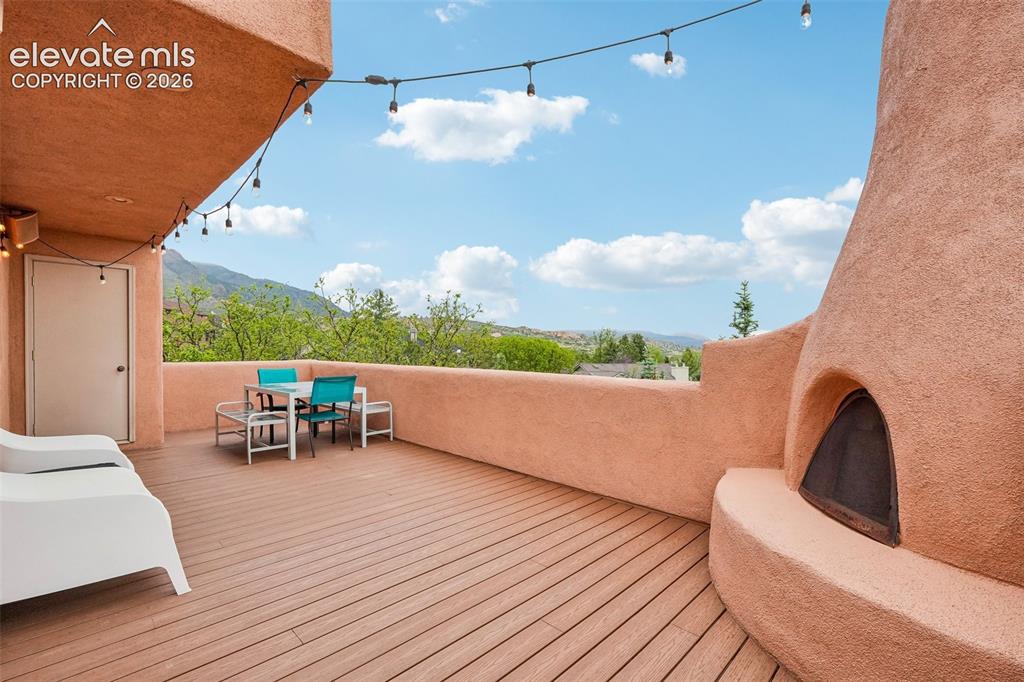 Image 16 of 50: Walk out deck off dining room with a built in sound system, storage and vie