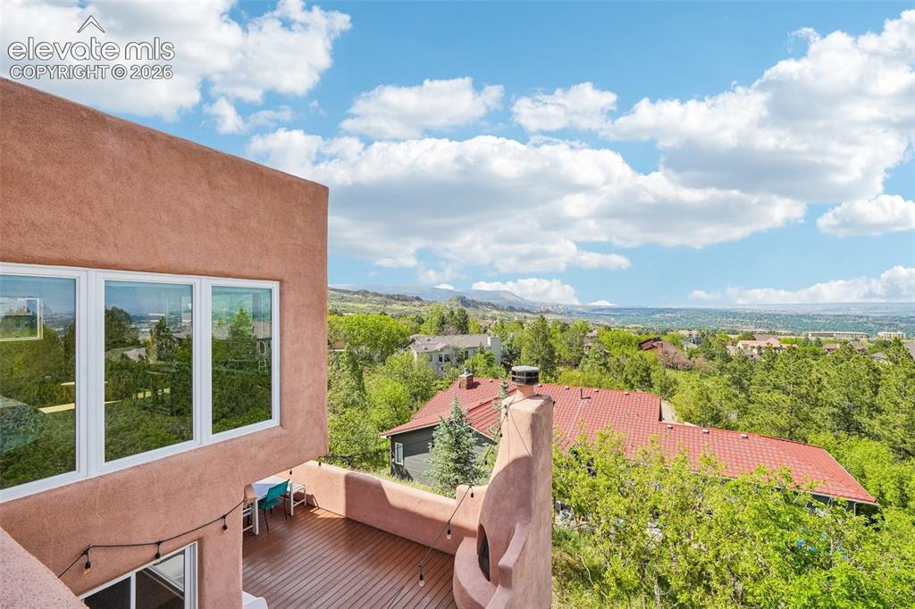 Image 17 of 50: Walk out deck off dining room with a kiva fireplace and views of the mounta