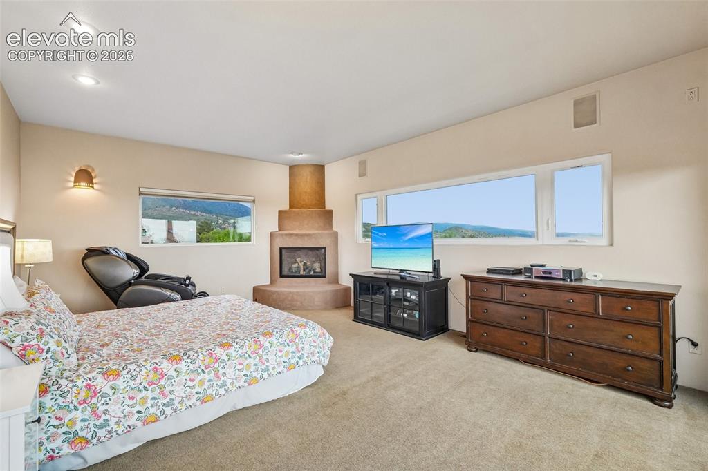 Image 21 of 50: Primary bedroom with en suite 5 piece bathroom, a walk in closet, fireplace