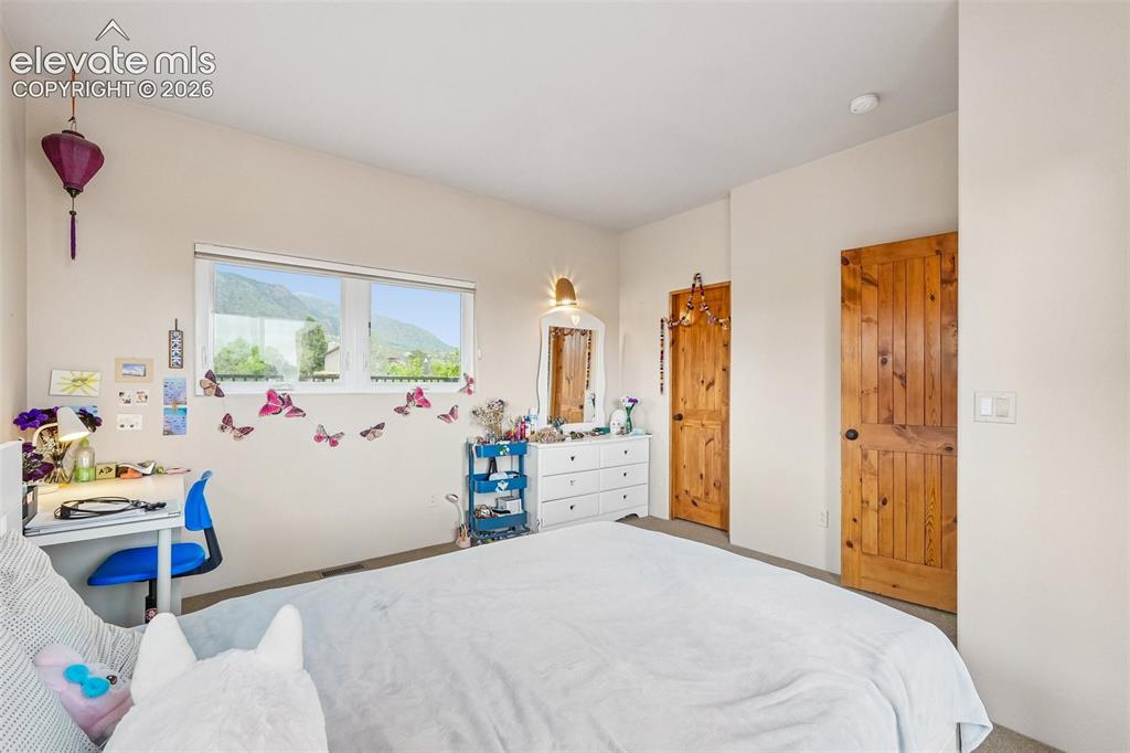 Image 31 of 50: Bedroom 2 with a walk out to a private wrap around deck and walk in closet