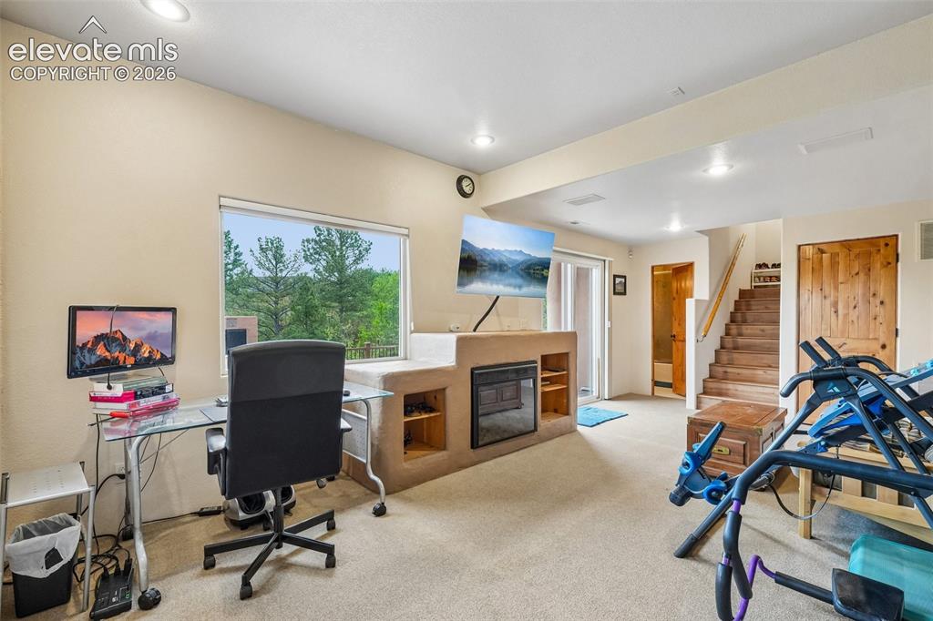 Image 39 of 50: Family room on lower level with a built in entertainment center, fireplace