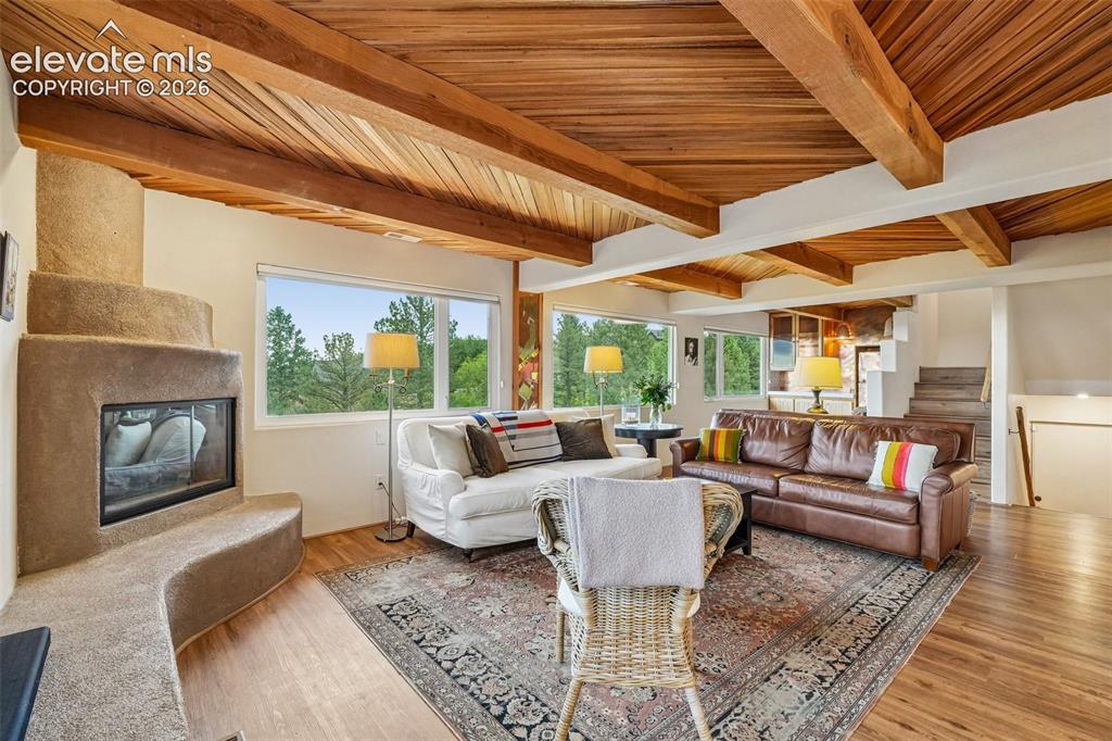 Image 5 of 50: Living room with plenty of natural light, wood beamed ceilings, a dry bar,