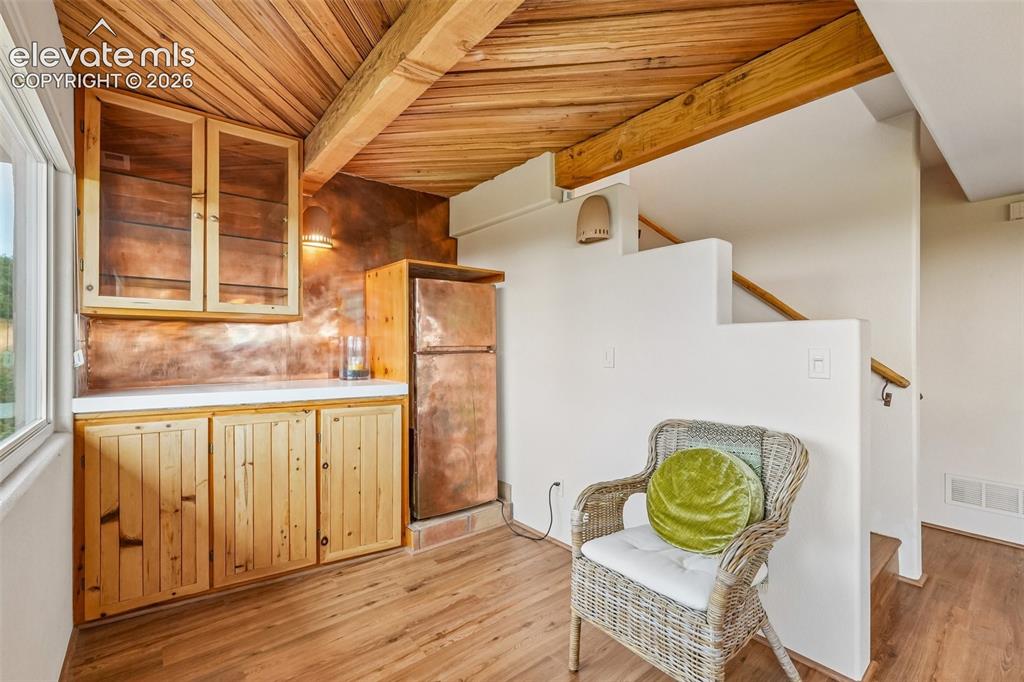 Image 6 of 50: Living room with plenty of natural light, wood beamed ceilings, a dry bar,