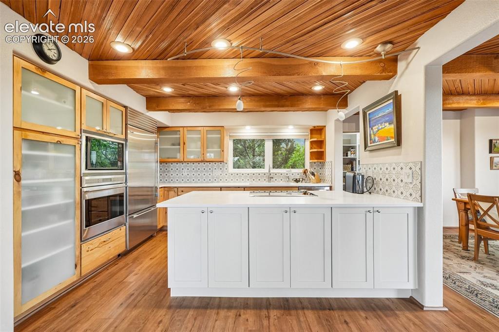 Image 7 of 50: Living room with plenty of natural light, wood beamed ceilings, a dry bar,