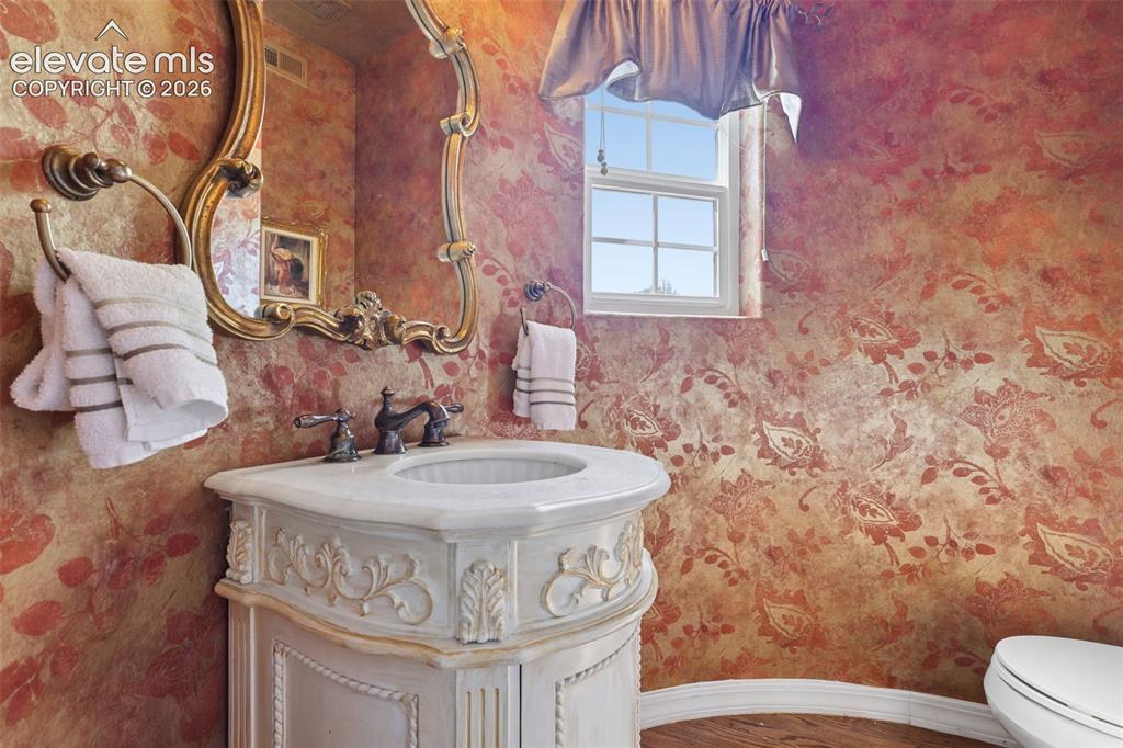 Image 24 of 50: Lovely half-bath on main level in curved turret room.