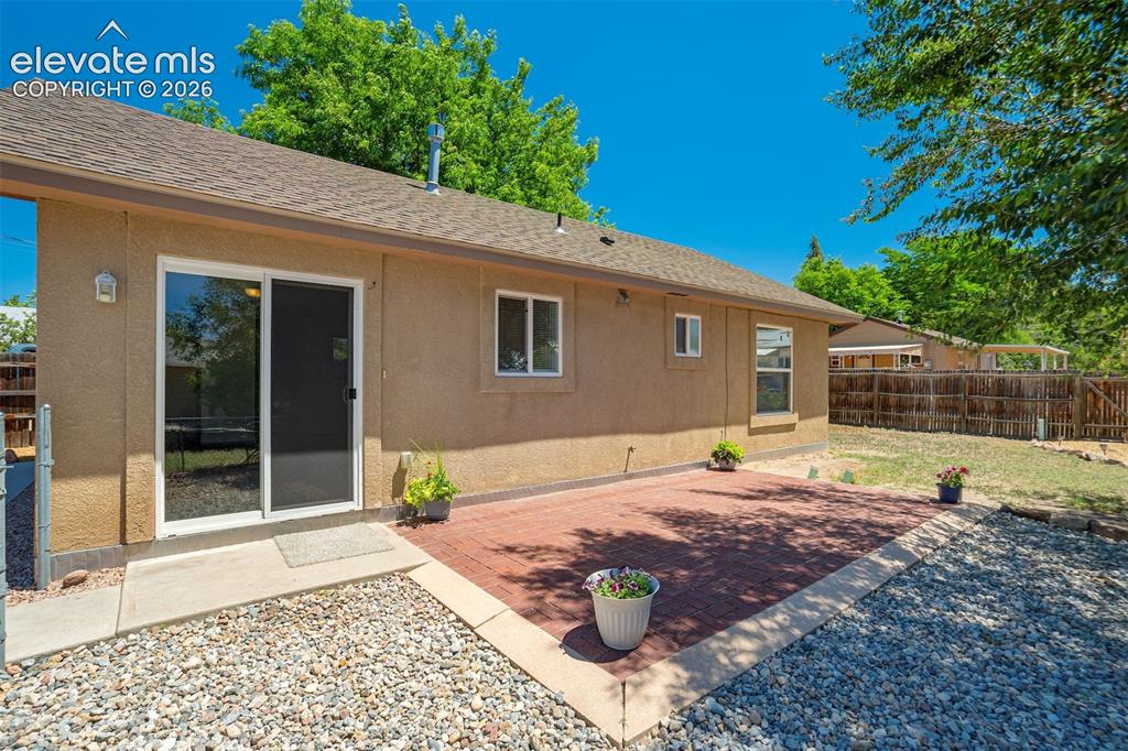 Image 25 of 29: Slider from kitchen and living space to side patio.