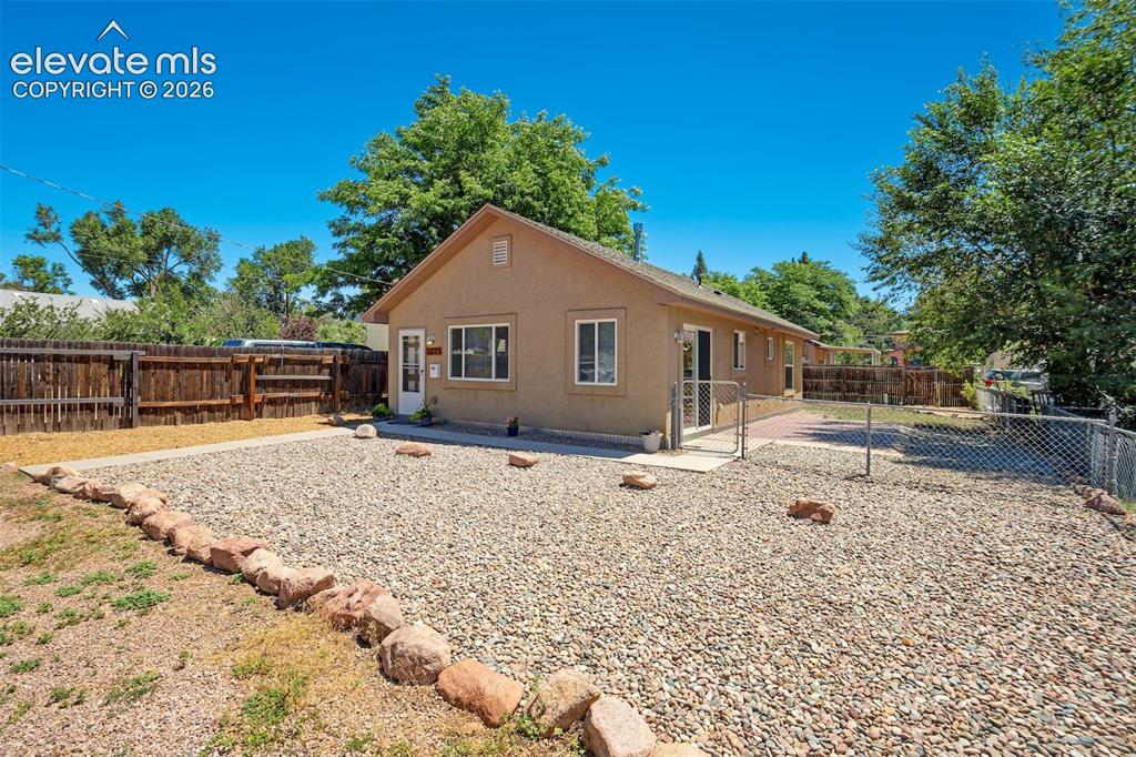 Image 6 of 29: Fenced large patio on side of home.