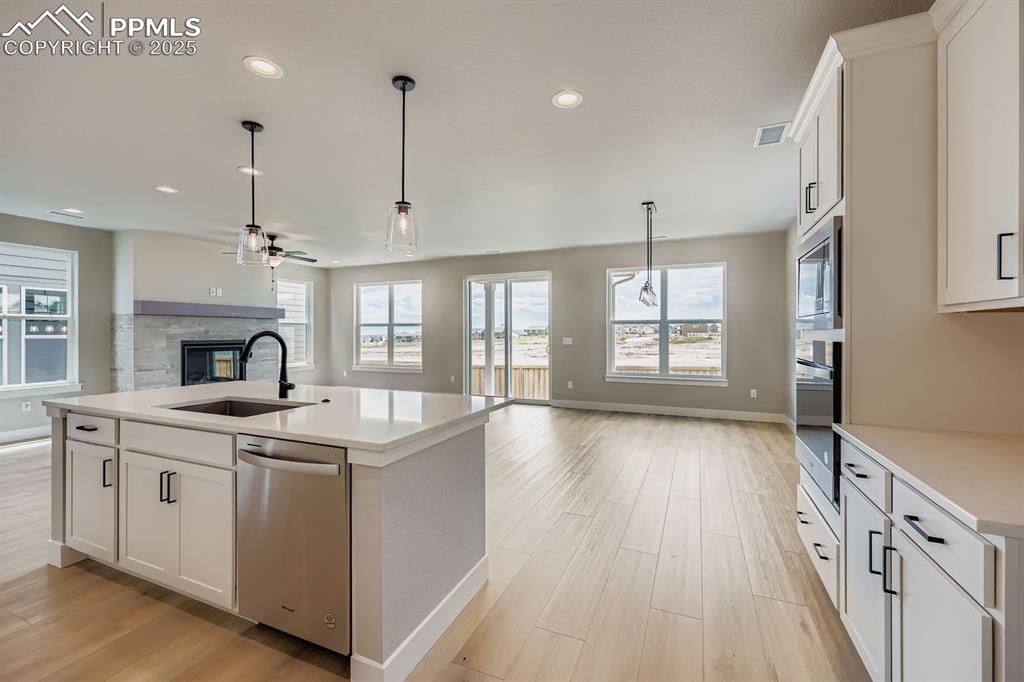 Image 10 of 28: Kitchen featuring open floor plan, a fireplace, appliances with stainless s
