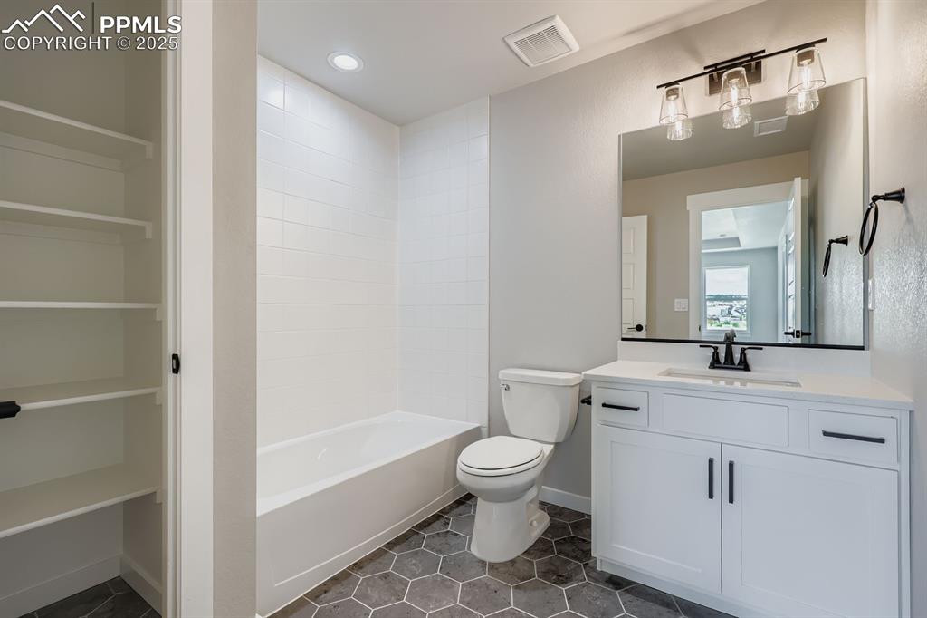 Image 22 of 28: Full bath featuring vanity, tile patterned flooring, and shower / bath comb