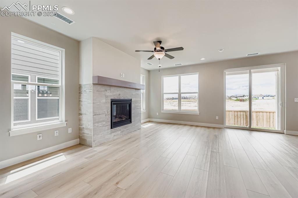 Image 7 of 28: Unfurnished living room with plenty of natural light, a ceiling fan, light 
