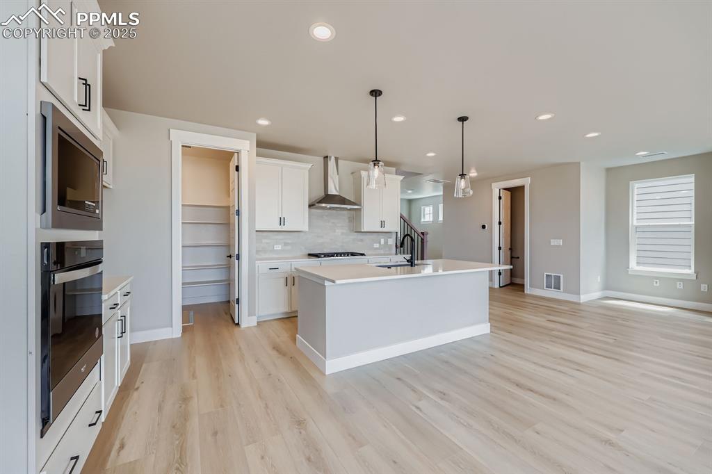Image 9 of 28: Kitchen with tasteful backsplash, black oven, stainless steel microwave, re