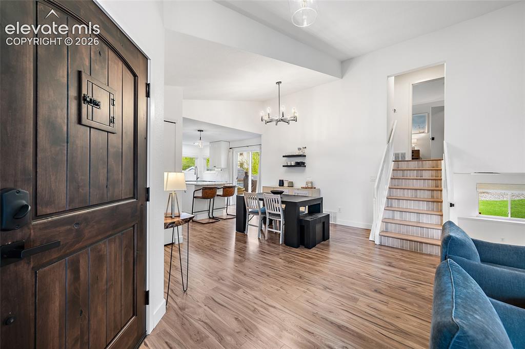 Image 10 of 50: Entryway featuring a dark wood plank door, wood-finish flooring, a contempo