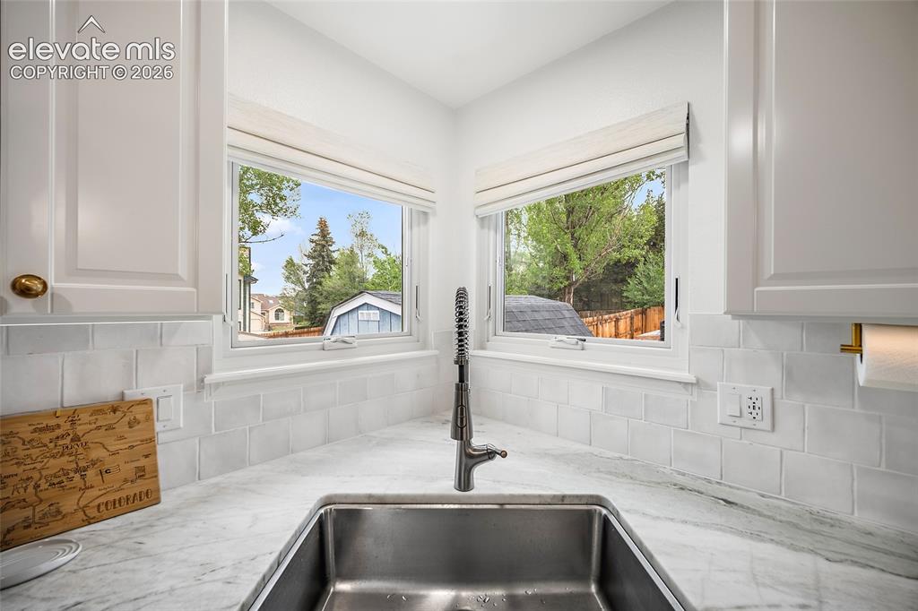 Image 18 of 50: Kitchen corner featuring a stainless steel sink, a dark finished faucet, an