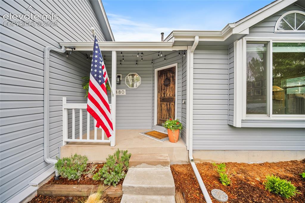 Image 2 of 50: Inviting front entry featuring a new rustic wood door, covered porch, and r