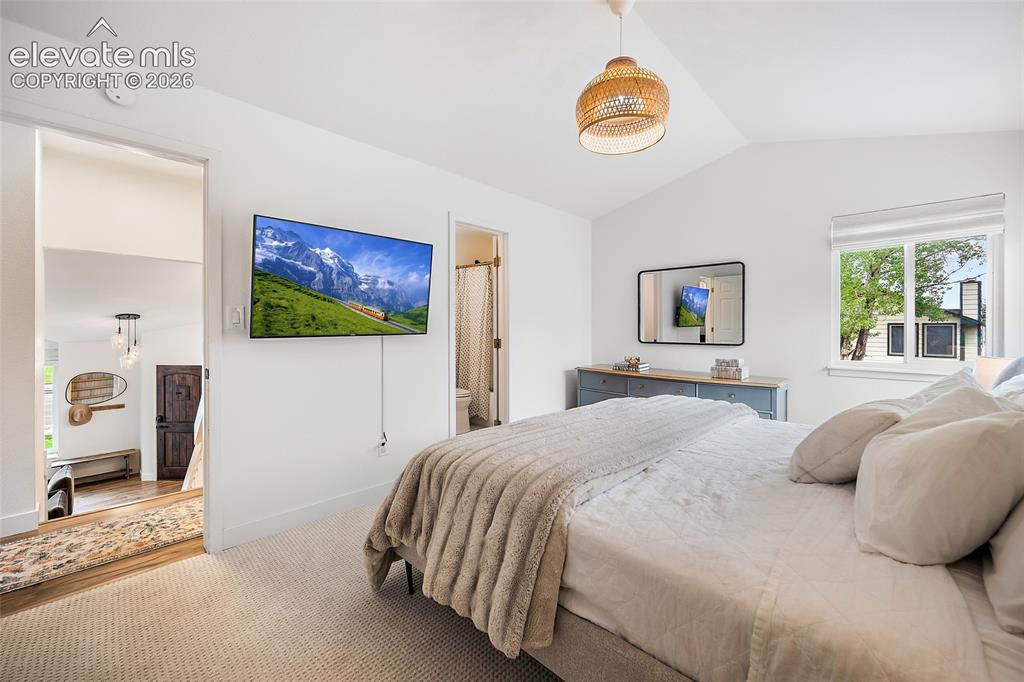 Image 26 of 50: Vaulted ceilings complement light-colored walls and soft carpeting in this 