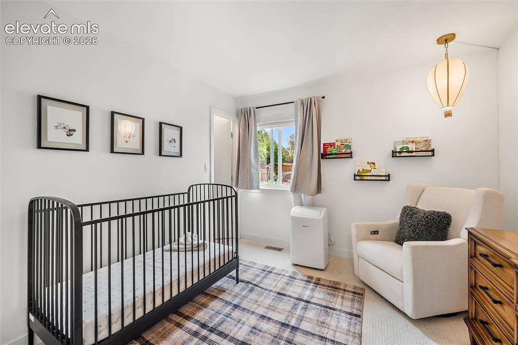 Image 29 of 50: Bright room featuring light-colored walls and a window with neutral drapes
