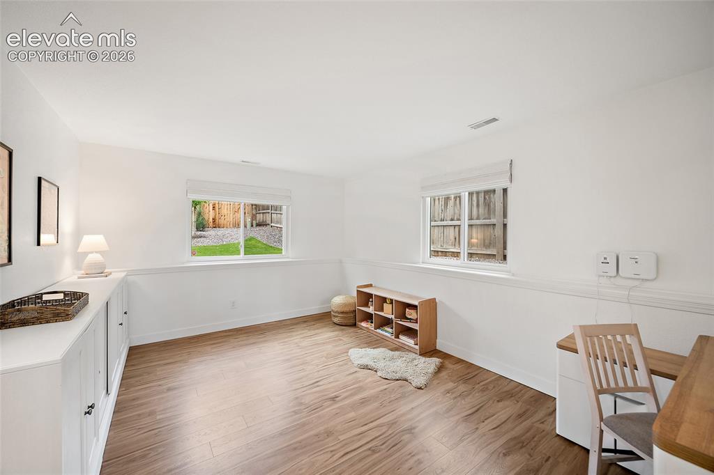 Image 31 of 50: Bright room featuring wood-finish flooring, white walls, and built-in cabin
