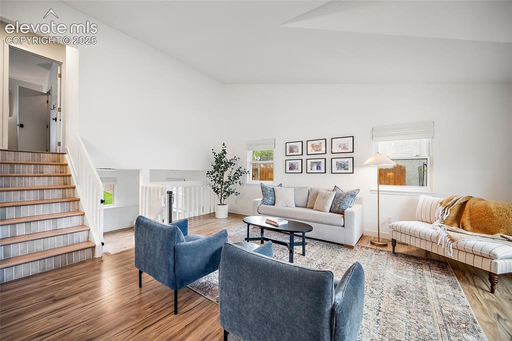Image 5 of 50: Spacious living room with vaulted ceilings and wood-finish flooring