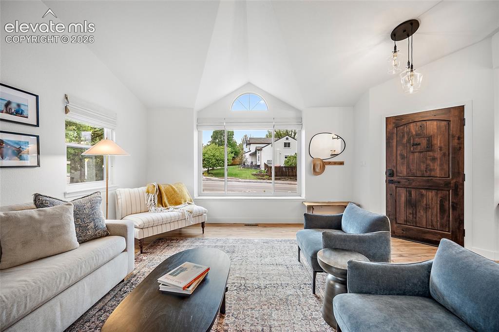 Image 7 of 50: Vaulted ceilings enhance this living space featuring a large picture window