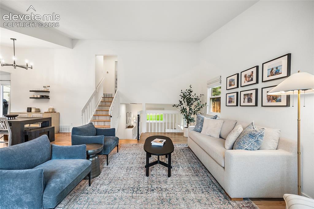 Image 9 of 50: Vaulted ceilings enhance this open concept living space featuring wood-fini