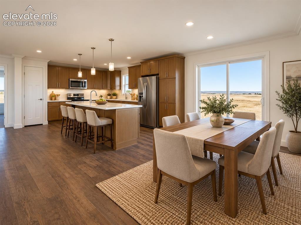 Image 11 of 34: Kitchen & Dining Area – Open kitchen and dining area pairs warm cabinetry a