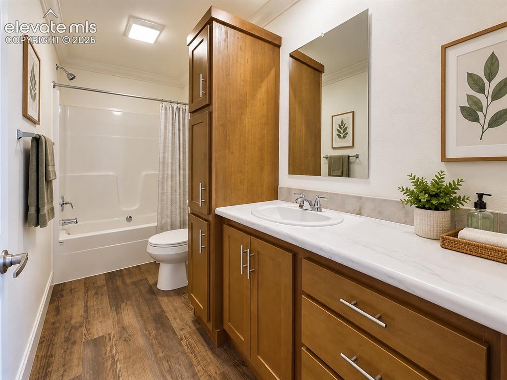 Image 22 of 34: Full Bathroom – Full bath features a tub/shower combination, warm wood cabi