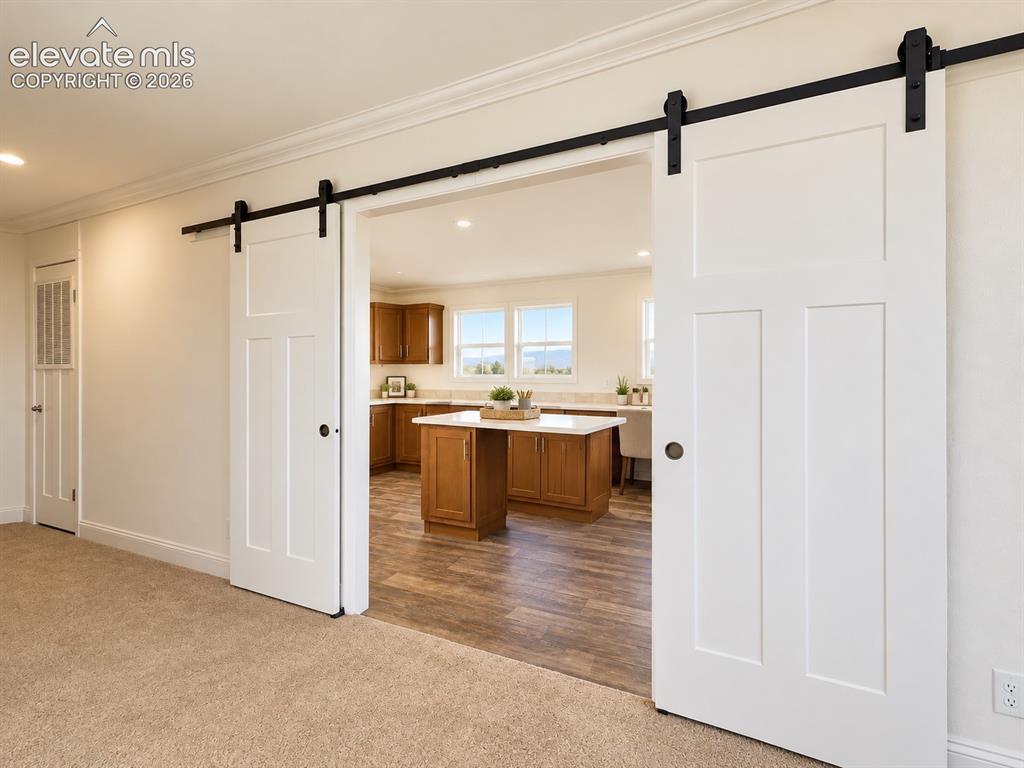 Image 25 of 34: Family Room / Laundry Connection – Oversized barn doors create a distinctiv