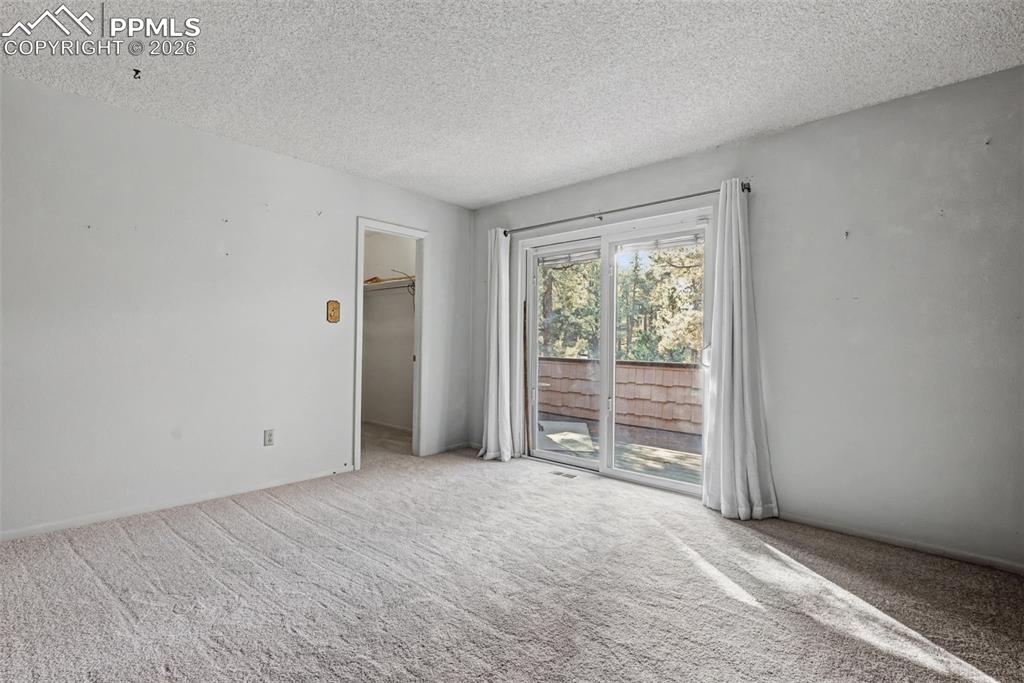 Image 20 of 38: Main level bedroom with walk out to upper front deck