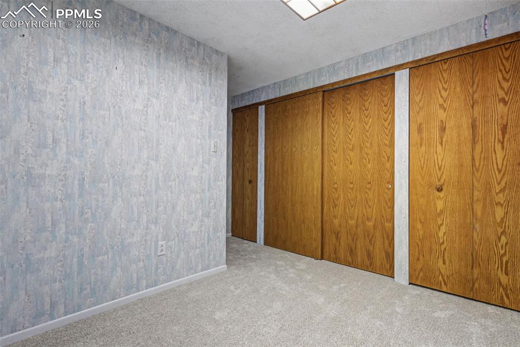 Image 26 of 38: Smaller lower level bedroom with four closets!