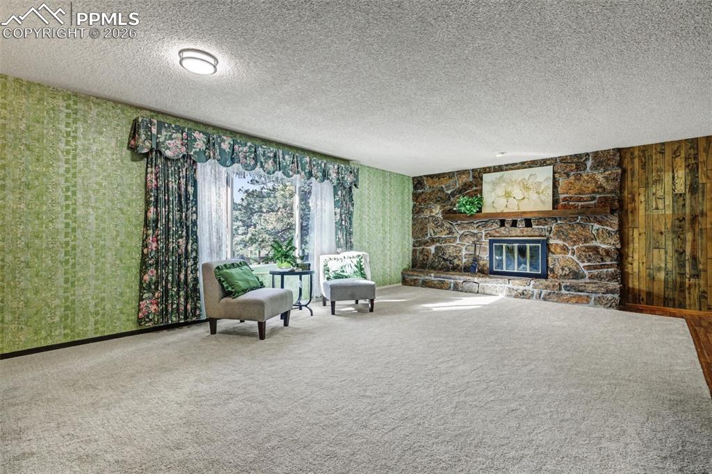 Image 4 of 38: Enormous living room with moss rock fireplace