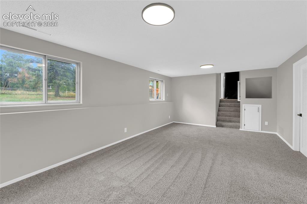 Image 15 of 29: Recessed windows with outdoor scenery, light gray walls, gray carpet floori