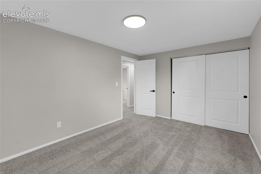 Image 20 of 29: Neutral gray wall paint, gray patterned carpeting, white trim, solid core i