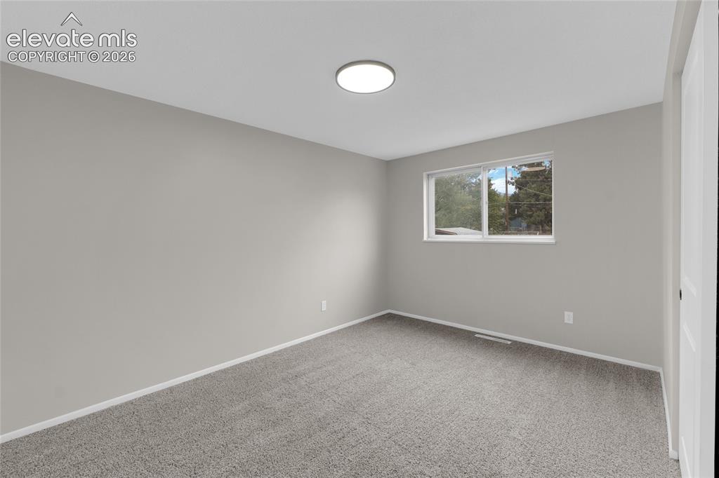 Image 21 of 29: Neutral gray wall paint with gray carpet flooring, recessed lighting, and a
