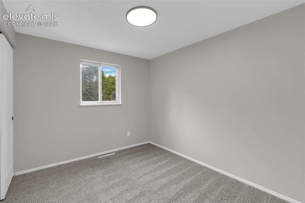 Image 23 of 29: Neutral paint palette, flush mount ceiling light, and carpeted flooring