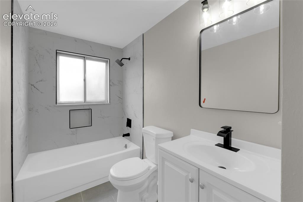 Image 25 of 29: Modern bathroom featuring a white vanity with integrated sink, matte black 